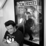 Michael Madsen pose devant le poster du sadique Mister Blonde, personnage particuliérement vicieux de Reservoir Dogs (1992) de Quentin Tarantino